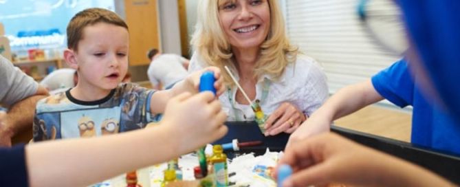 Heather Henry is with young people at a table making things