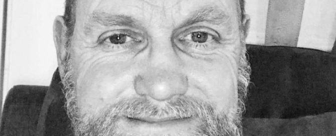 a cropped picture of a black and white photo of a man with a beard